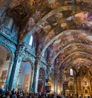 一群人站在一间大房间里,天花板上挂着画