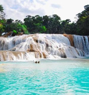 a pool of water in front of a waterfall