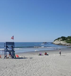 ein Strand mit einem Rettungsschwimmerturm und Menschen darauf