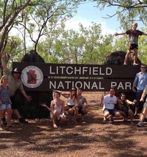 a group of people posing in front of a national park