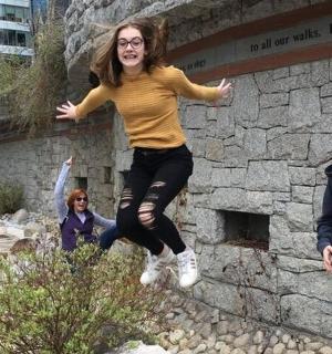 a woman jumping in the air in front of a wall