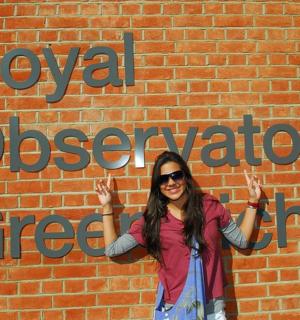 一名女子站在一堵砖墙前