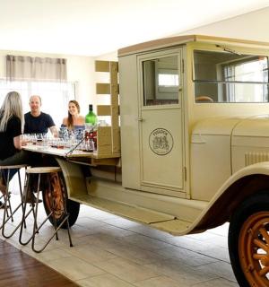 hópur fólks stendur í kringum gamlan vörubíl