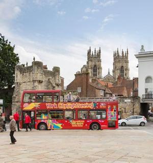 a red double decker bus parked in a city