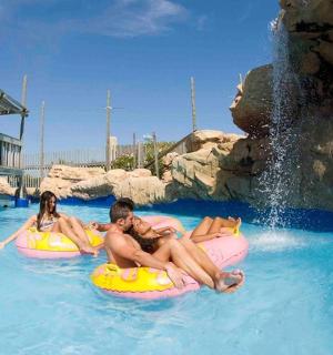 a man and a woman riding on tubes in the water