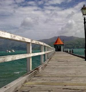 a wooden pier with a street light on the water