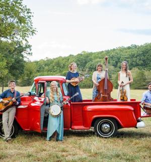 skupina lidí stojící vedle červeného kamionu