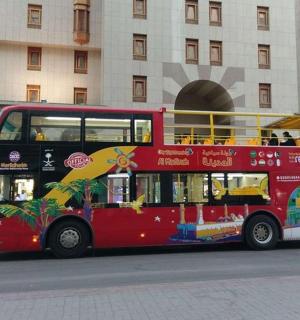 一辆红色双层巴士停在一栋建筑物前