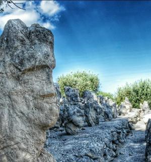 a pile of rocks in a field with a blue sky