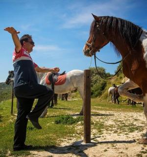 muž stojí vedle koně