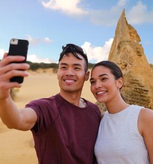 muž a žena se fotí před pískovou sochou