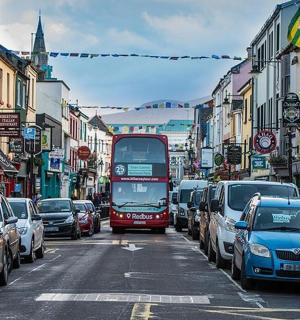 一辆红色双层巴士行驶在繁忙的城市街道上
