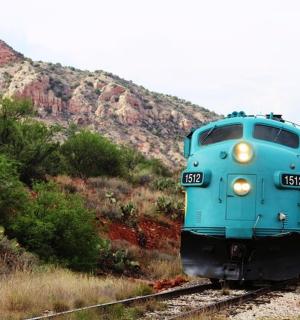 一辆蓝色的火车正在沿着轨道行驶