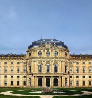 ein großes Gebäude mit einem Brunnen davor