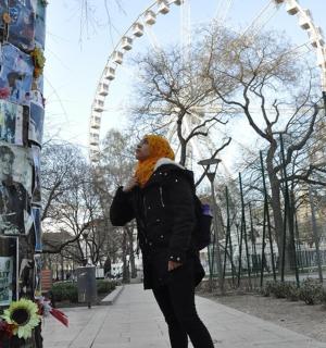 a woman standing next to a pole with pictures on it