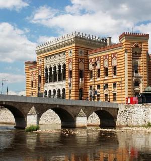 a large building with a bridge in front of a river