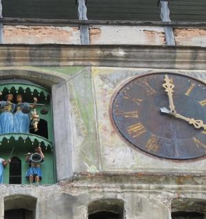 un ceas pe lateralul unui turn cu figurine