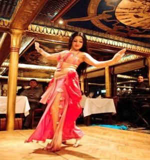 一位身穿粉色连衣裙的女子在舞池中跳舞