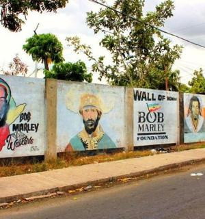 a row of posters on a wall next to a street