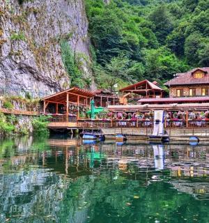 a restaurant on the water next to a mountain