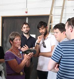 一群人围着一个拿着平板电脑的人