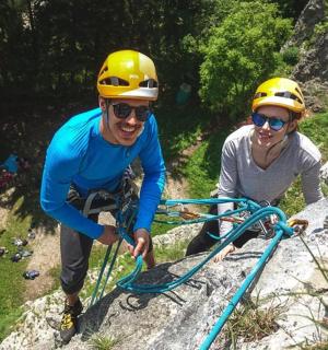 两个戴着头盔的人正在攀爬岩石