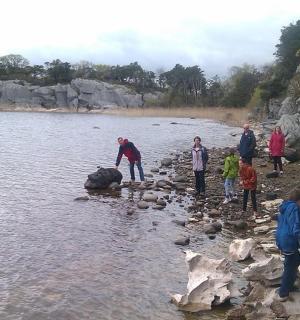 一群人站在水中的一块岩石上