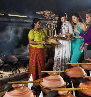 Cuatro mujeres de pie en una cocina con ollas y sartenes.