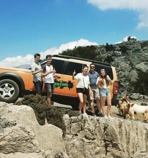 a group of people standing in front of a vehicle