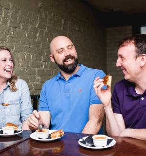 三个人坐在桌边吃饭