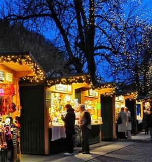 Skupina lidí stojících před obchodem s vánočními světly