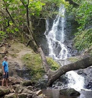 muž stojící před vodopádem