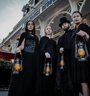 a group of people dressed in black holding lights