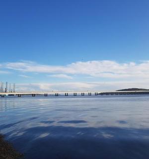 a large body of water with a bridge in the background