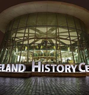 一座巨大的玻璃建筑,上面挂着“Geneland 历史中心”的标志