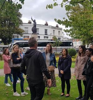 a group of people standing in front of a statue
