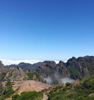 a view of a mountain range with clouds in the background