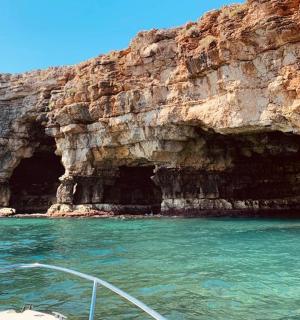 loď ve vodě vedle jeskyně