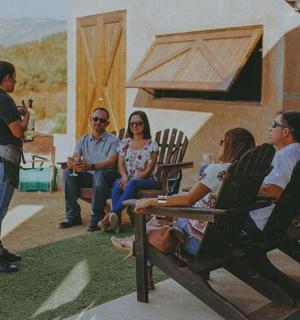 a group of people sitting in chairs talking to a woman