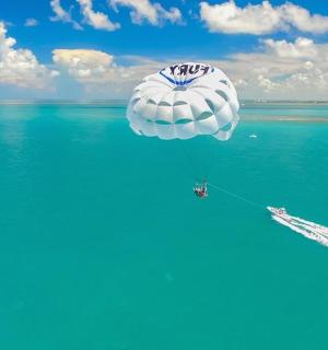 a large balloon flying over the water with a boat