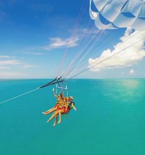 a person on a parachute over the ocean