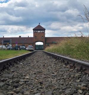 a train track in front of a building with a clock tower
