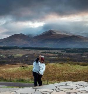 a woman is standing on top of a mountain