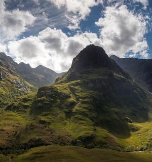 a mountain with green grass on the side of it