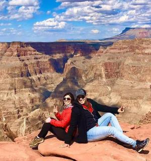 两个人坐在大峡谷的一块岩石上