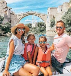 rodina v lodi na vodě před mostem