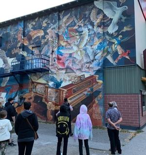 一群人站在建筑物壁画前