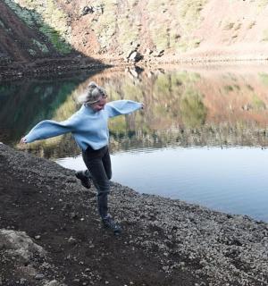 a woman running on the side of a lake