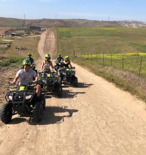 група људи који возе АТВ-ове низ земљани пут