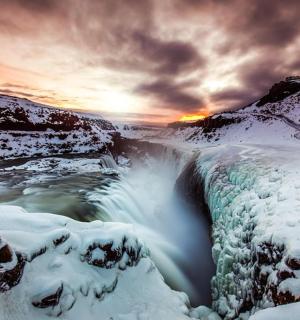 a view of a waterfall covered in snow